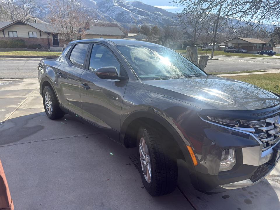 Hyundai Santa Cruz pickup truck after basic exterior wash - front three-quarter view showing clean paint, wheels, and fresh appearance against Utah mountain backdrop